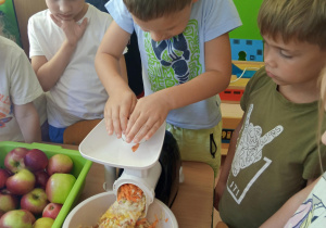 dzieci robią surówkę jabłkowo - marchewkową
