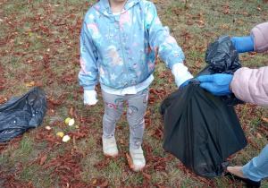 dziewczynka wyrzuca śmieci