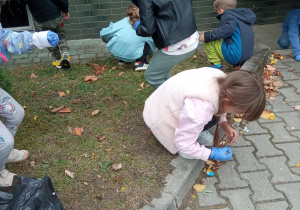 dzieci sprzątają w ogrodzie
