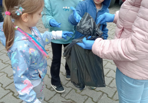 dzieci wyrzucają śmieci