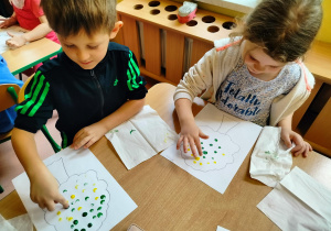 dzieci malują farbami jesienne drzewa