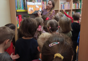 pani bibliotekarka pokazuje książki dla dzieci
