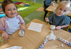 Dzieci malują skarbonki farbami