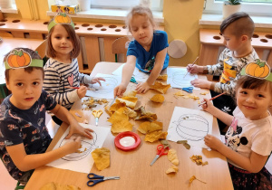 dzieci przyklejają liście na dyni