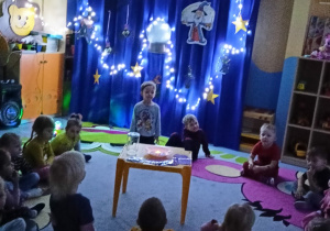dzieci obserwują doświadczenie z gasnącą świecą