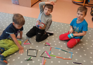 dzieci układają figury z kredek