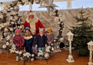 dzieci robią zdjęcie z Mikołajem w pięknej bombce
