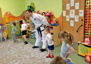 Dzieci wykonują wspólną rozgrzewkę z Panem z Taekwondo