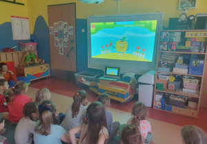 Dzieci oglądają film edukacyjny na temat marchewki