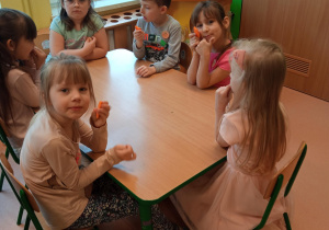 dzieci jedzą smaczne i zdrowe marchewki