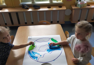 dzieci malują farbami szablon ziemi