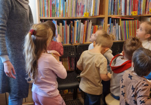 Dzieci oglądają regały z książkami