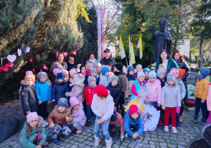 Przedszkolaki stoją pod pomnikiem Jana Pawła II