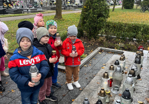 Chłopcy stawiaja znicze przed Pomnikiem Nieznanego Żołnierza.