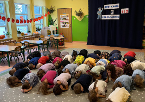 Dzieci ćwiczą pozycje "żółwia" podczas ataku zwierzęcia.