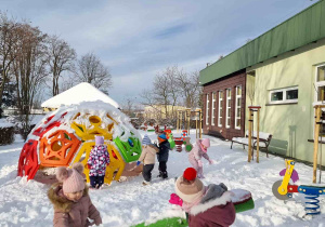 Dzieci bawią się na placu zabaw na śniegu