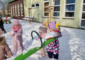 Wspólna zabawa dzieci na placu zabaw na śniegu