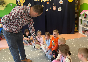 Pszczelarz opowiada dzieciom o pszczołach i ich roli w naturze.