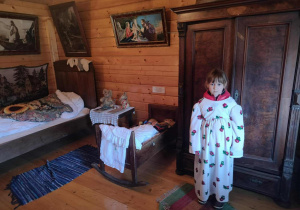 Dziewczynka w stroju w kolejnym pomieszczeniu w skansenie