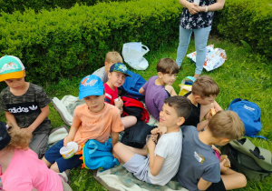 Dzieci siedzą na kocyku