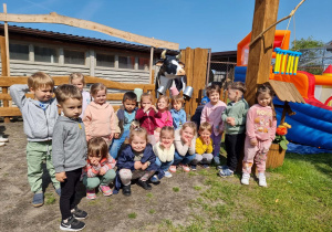 Dzieci pozują do wspólnego zdjęcia na tle agroturystyki