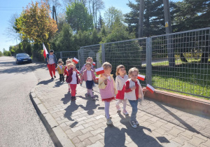Dzieci maszerują ulicami z flagami Polski