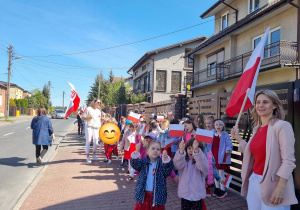 Dzieci maszerują ulicami z flagami Polski