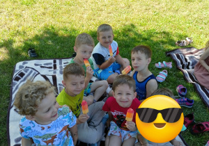 dzieci na kocu jedzą lody