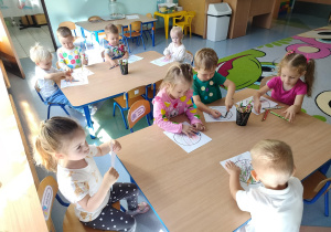 dzieci kolorują piłki i ozdabiają kropkami