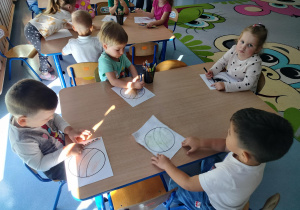 dzieci kolorują piłki i ozdabiają kropkami