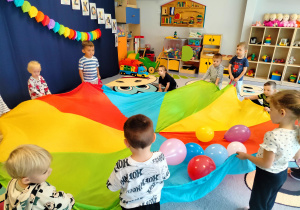 dzieci podrzucają balony na chuście
