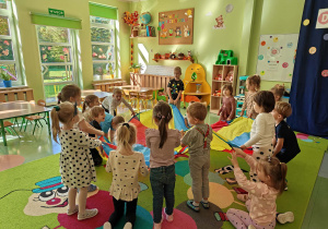 Dzieci uczestniczą w zabawie z chustą animacyjną