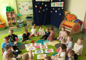 Dzieci siedzą na dywanie i opowiadają o swoich talentach