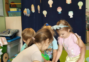 Dzieci na dywanie bawią się zabawkami sensorycznymi