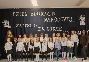 Grupa Elfy wraz z Paniami na tle dekoracji Dzień Edukacji Narodowej