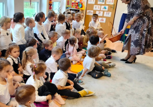 Pani dyrektor częstuje dzieci cukierkami