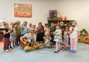 Dzieci grają i śpiewają wspólnie z muzykiem