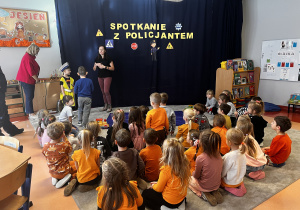 Pani pokazuje ubiór policjanta kierującego ruchem .