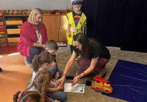 Dzieci odbijają palce w specjalnym tuszu aby zobaczyć swoje linie papilarne.
