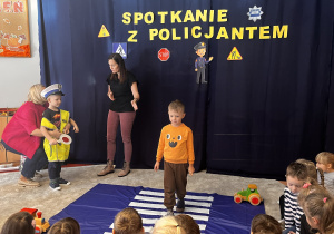 Dzieci pokazują jak prawidłowo przechodzić przez pasy.