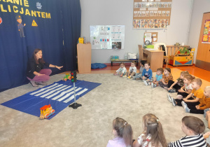 dzieci słuchają o zasadach bezpieczeństwa na drodze