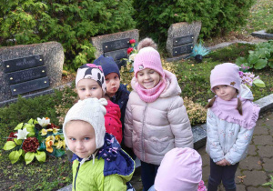 Dzieci spacerują alejkami na cmantarzu