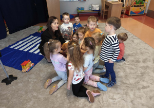 Dzieci głaskają psa pluszaka