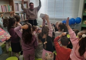 Dzieci z radością słuchają pani bibliotekarki .