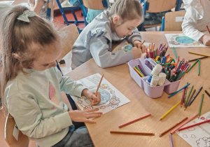 Dzieci kolorują przy stolikach