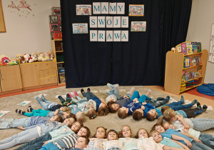 Dzieci lezą na dywanie