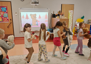 dzieci tańczą w kole z misiami