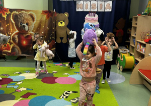 Dzieci niosą misia na głowie