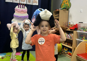 Dziewczynka przenosi misia na głowie