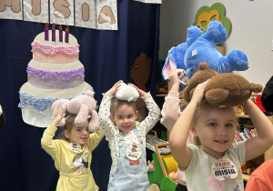 Dziewczynki niosą misie na głowach